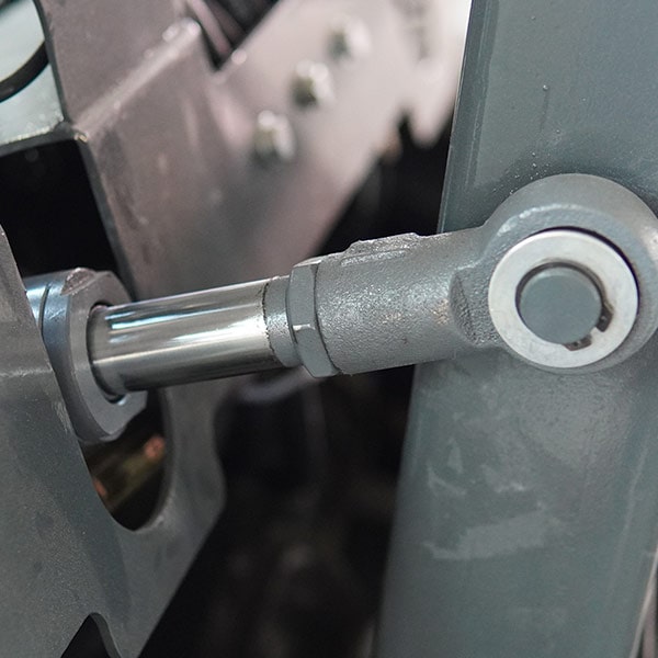 Close-up of forklift hydraulic part showing metal cylinder and joint.