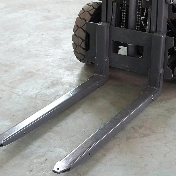 Close-up of Fangwei electric forklift forks on concrete floor.
